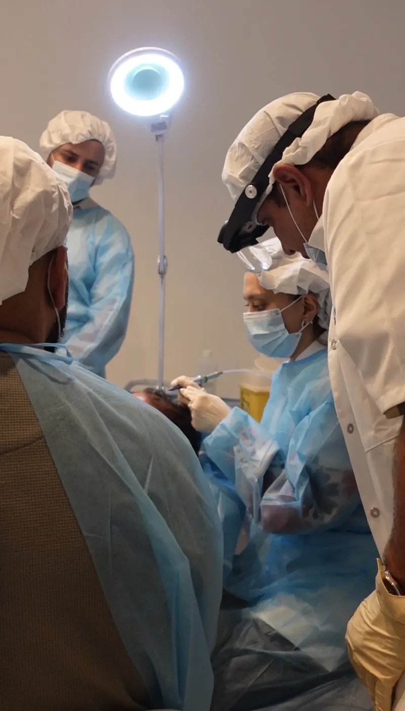 Biofibre®-haarimplantatie tijdens een training voor artsen, met loepbril en ringlamp