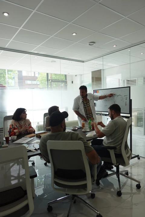 Biofibre®-training voor artsen: theorie aan tafel, met een trainer bij een groot scherm